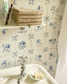 a white sink sitting under a bathroom mirror next to a wall mounted faucet