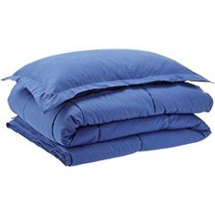 two blue comforters stacked on top of each other in front of a white background