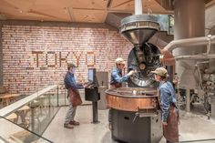 three people standing in front of a machine