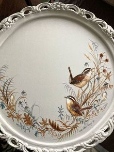 two birds painted on the side of a white platter with gold trimmings