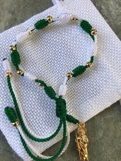 "Handmade, adjustable green and white st. Judas Thaddeus plated gold beads bracelet. Material: nylon string/green and white #18, #9 plated gold 14k beads 4mm St. Judas Thaddeus plated gold pendant 2.50cm Bracelet made for unisex adults,minimum slide lock from 7\" inches to 8.5\" inches ; perfect for a gift!" San Judas Bracelet, Adjustable Green Bracelets With Gold Beads, Mexican Bracelet Ideas, Mexican Beaded Jewelry, Mexican Bracelets Handmade, Bracelets From Mexico, Nylon String Bracelet, Evil Eye Jewelry Bracelet, Mexican Bracelets