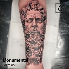 a man's arm with a black and grey tattoo on it, depicting the face of an ancient greek god