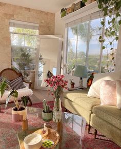 a living room filled with lots of furniture and plants on top of a coffee table