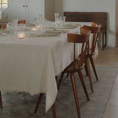 a dining room table is set with place settings and glasses on the table, ready to be served