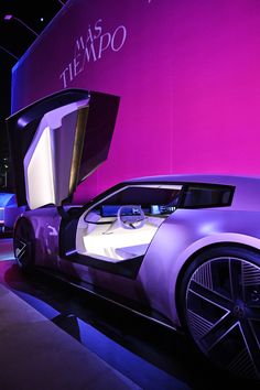 a futuristic car is on display in front of a pink wall