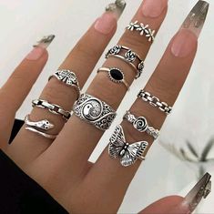 a woman's hand with five rings on it and one is wearing a ring