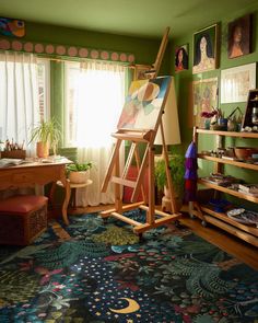 a painting easel sitting on top of a rug next to a window