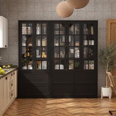 a kitchen with wooden flooring and black cabinetry next to a dining room table