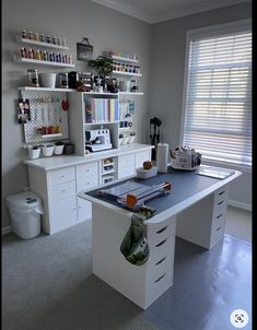 a white desk with lots of drawers and shelves on top of it in a room