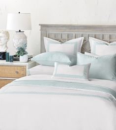 a bed with blue and white striped comforter in a bedroom next to a lamp