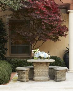 an outdoor table with flowers and vases on it