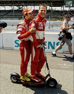 two men in red and white racing suits on a scooter