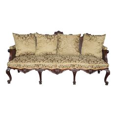 an ornately decorated couch with four pillows on it's back and armrests