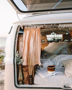 the back end of a van filled with pillows and blankets