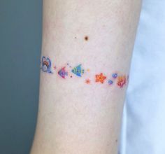 a woman's arm with colorful stars and planets on the side of her body