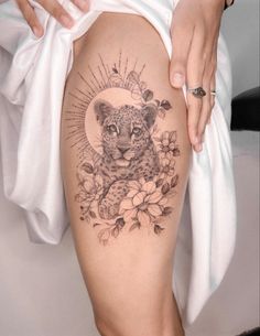 a woman's thigh with a tattoo on it and a cheetah in the center