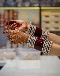 two hands with henna and bracelets on display at a jewelry store in india