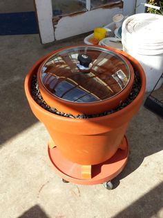 an orange potted planter sitting on top of a cement floor