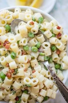 a white bowl filled with pasta and peas