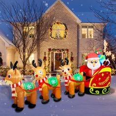 inflatable reindeers and santa clause are lined up outside the house for christmas