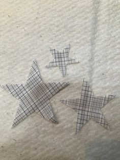 three paper stars sitting on top of a piece of white paper next to each other