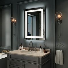 a bathroom vanity with a lighted mirror above it