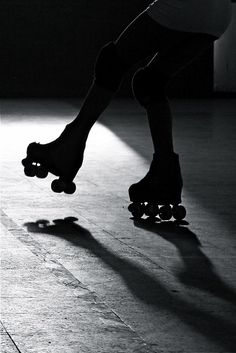 a person riding a skateboard on top of a hard wood floor in the dark