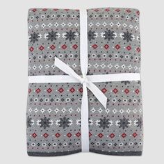 a gray blanket with red and white snowflakes is wrapped in a white ribbon