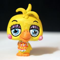 a yellow toy with big eyes and a bow on it's head