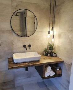 a bathroom sink sitting under a mirror next to a wooden counter