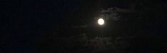 the moon is shining brightly in the dark sky