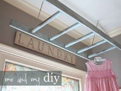 a pink dress hanging on a clothes line in front of a sign that says laundry