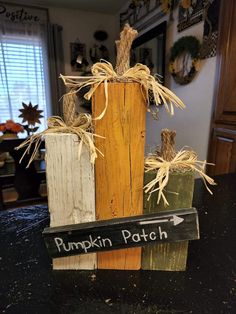 two wooden poles with pumpkin patch on them sitting on top of a black table in front of a window