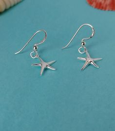 Sterling Silver Starfish Hook Earrings A stunningly simple and pretty set of starfish earring... These beautiful silver starfish earrings are very cute.... and we also have a pendant to match. If you are buying this as a gift for someone and want to make it extra special, how about adding one of our Messages in a Bottle...  We have 6 bottle designs to choose from and a  number of different messages and quotes that can be included on your scroll. Please follow the following link for our Messages in a bottle. https://oceansofsilvershop.etsy.com/uk/listing/1168876950/message-in-a-bottle-keepsake Your Message in a bottle will be delivered with your Jewellery. Free Postage and Delivery in the UK and US. All Items are dispatched in 1-2 days with standard Royal Mail. Our Jewellery  is beautifully Messages In A Bottle, Bottle Designs, Starfish Earrings, Mail Delivery, Silver Gifts, Pretty Earrings, Earrings Photo, Toe Rings, Bottle Design