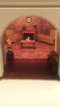 a living room filled with furniture and a clock on top of a wall next to a doorway