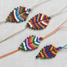 three beaded bracelets with beads and tassels on a white cloth background