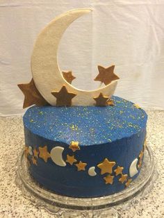 a blue cake with gold stars and a crescent on top