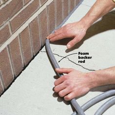 a brick wall being worked on with a hand held by a metal barbwire