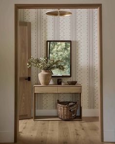 a room with a table, mirror and basket on the floor in front of it