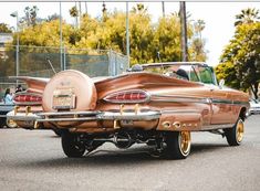 an old car is parked on the side of the road in front of other cars