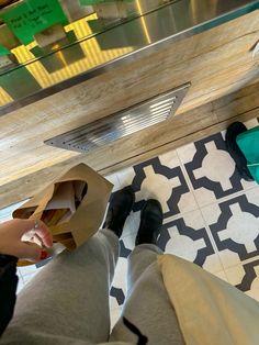 a person standing on top of a tiled floor next to a bag with food in it