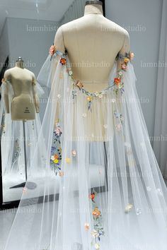 a mannequin wearing a wedding dress with flowers on the back and long veil