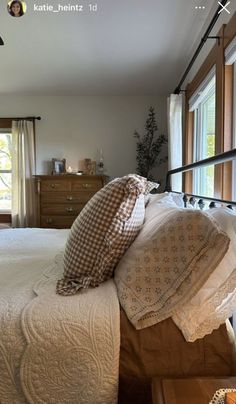 a bed sitting in a bedroom next to two windows