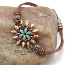 a brown leather cord bracelet with a multi colored bead and flower design on it