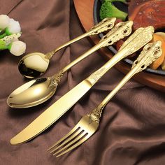 three forks and two spoons on a table