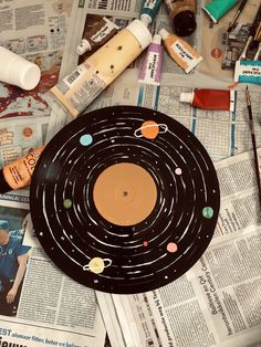 a black plate sitting on top of a table covered in paper and crafting supplies