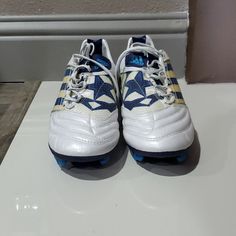 a pair of white and blue shoes sitting on top of a counter next to a wall