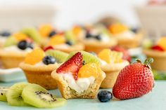 small fruit tarts with kiwis, strawberries and bananas on the side