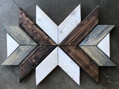 a wooden star shaped object sitting on top of a cement floor