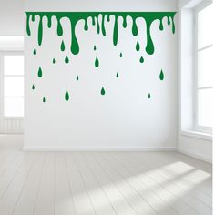 an empty room with green drips on the wall and white floor, in front of a window